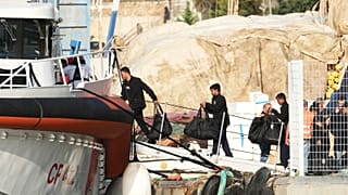 Migranten, die in internationalen Gewässern abgefangen und Anfang dieser Woche in eine Aufnahmeeinrichtung in Albanien gebracht wurden, gehen an Bord eines Schiffes der italienischen Küstenwache, 19. Oktober 2024.