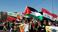 متظاهرون يهتفون بشعارات وهم يلوحون بالأعلام العراقية والفلسطينية دعماً للفلسطينيين في غزة خلال مظاهرة في بغداد، العراق، الخميس، 20 مايو/أيار 2021
