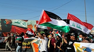 متظاهرون يهتفون بشعارات وهم يلوحون بالأعلام العراقية والفلسطينية دعماً للفلسطينيين في غزة خلال مظاهرة في بغداد، العراق، الخميس، 20 مايو/أيار 2021