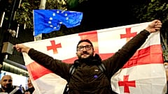 Ein Mann hält eine georgische Flagge während einer Kundgebung der Opposition in Tiflis, 20. Oktober 2024