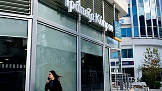 Женщина идет мимо отделения "Банка Кипра", Никосия, Кипр, 24 января 2024 