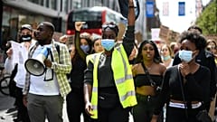 People, some wearing protective masks against the spread of coronavirus, chant slogans, during a march organised by Black Lives Matter, in London, Sunday, June 21, 2020.