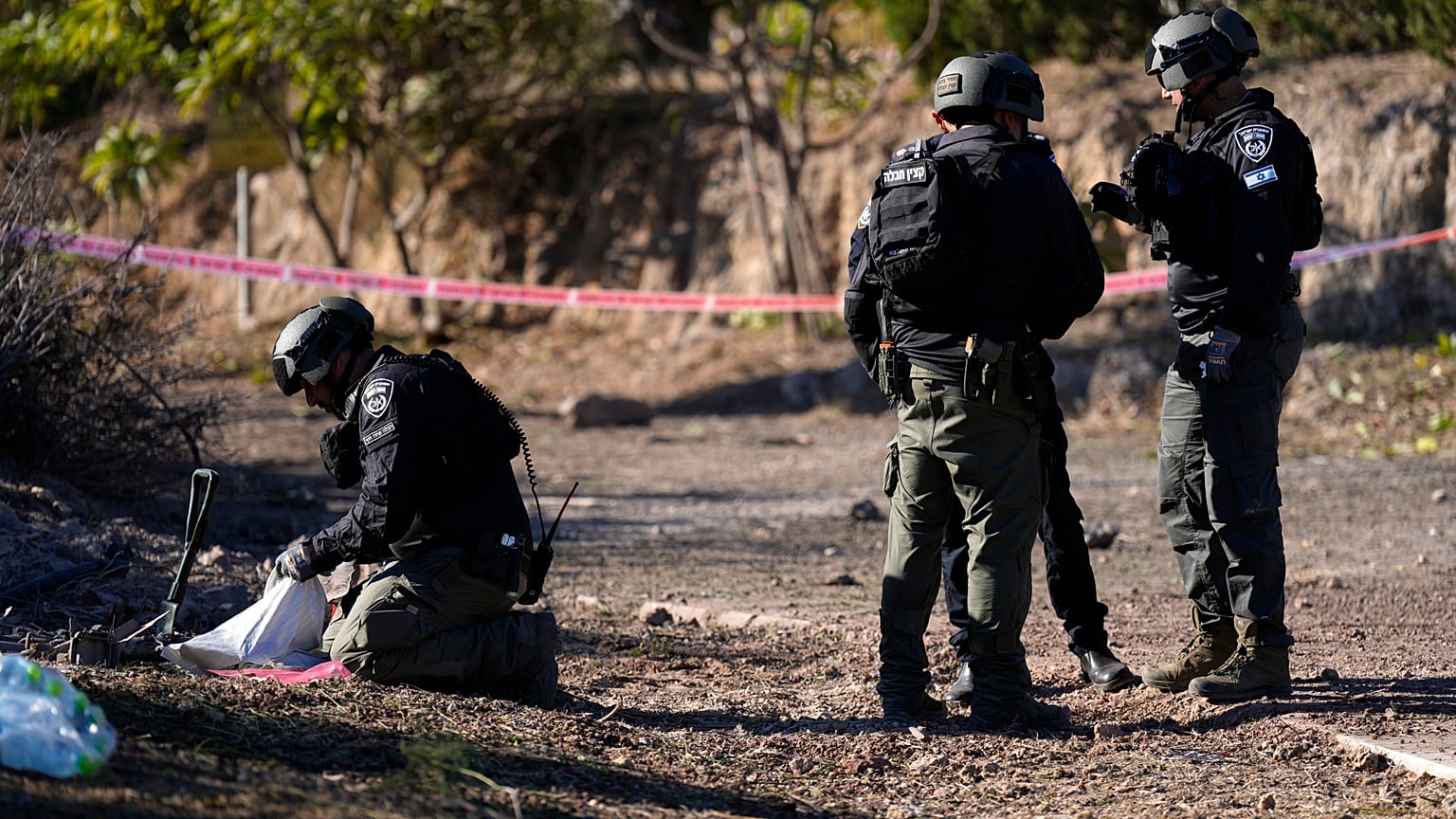 Especialistas em eliminação de engenhos explosivos da polícia israelita trabalham no local onde caíram projécteis disparados do Líbano no Kibbutz Ma'agan Michael, Israel