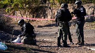 Especialistas em eliminação de engenhos explosivos da polícia israelita trabalham no local onde caíram projécteis disparados do Líbano no Kibbutz Ma'agan Michael, Israel