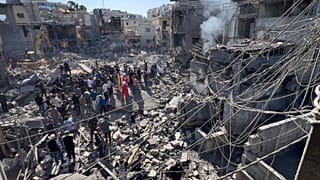 عمال إنقاذ يتجمعون في موقع الغارات الإسرائيلية التي دمرت مباني قرب المستشفى الحكومي الرئيسي في حي مكتظ بالسكان جنوبي بيروت، لبنان، الثلاثاء، 22 أكتوبر/تشرين الأول 2024.
