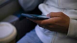 DOSYA - Bir kadın 18 Mayıs 2021 tarihinde New Jersey'de bir trende elindeki cihaza bakıyor. 