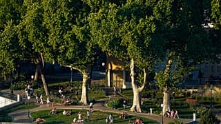 Personas disfrutan de una tarde de verano al aire libre en un jardín público de Lisboa en 2022.
