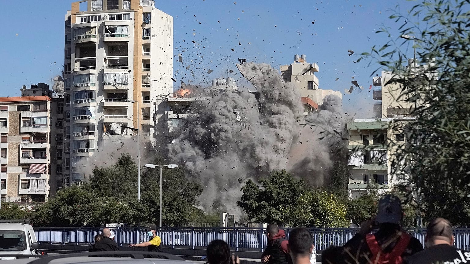 Lübnan'ın başkenti Beyrut'taki Gubeyri bölgesinde İsrail hava saldırısında vurulan binanın çöküşünü izleyenler, 22 Ekim, 2024.
