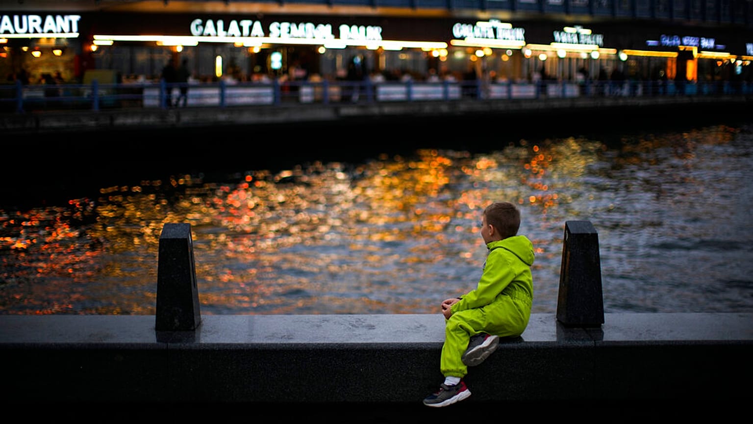 İstanbul'da Galata köprüsünün yanında bir çocuk oturuyor, 28 Şubat 2023.