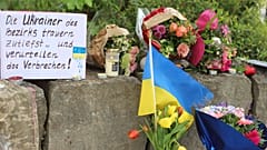 Blumen und eine kleine ukrainische Flagge werden in einem Einkaufszentrum in Murnau, Deutschland, am Sonntag, 28. April 2024, niedergelegt. 