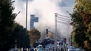 Smoke raises as emergency rescue teams and police officers attend outside Turkish Aerospace Industries Inc. on the outskirts of Ankara, 23 October 2024
