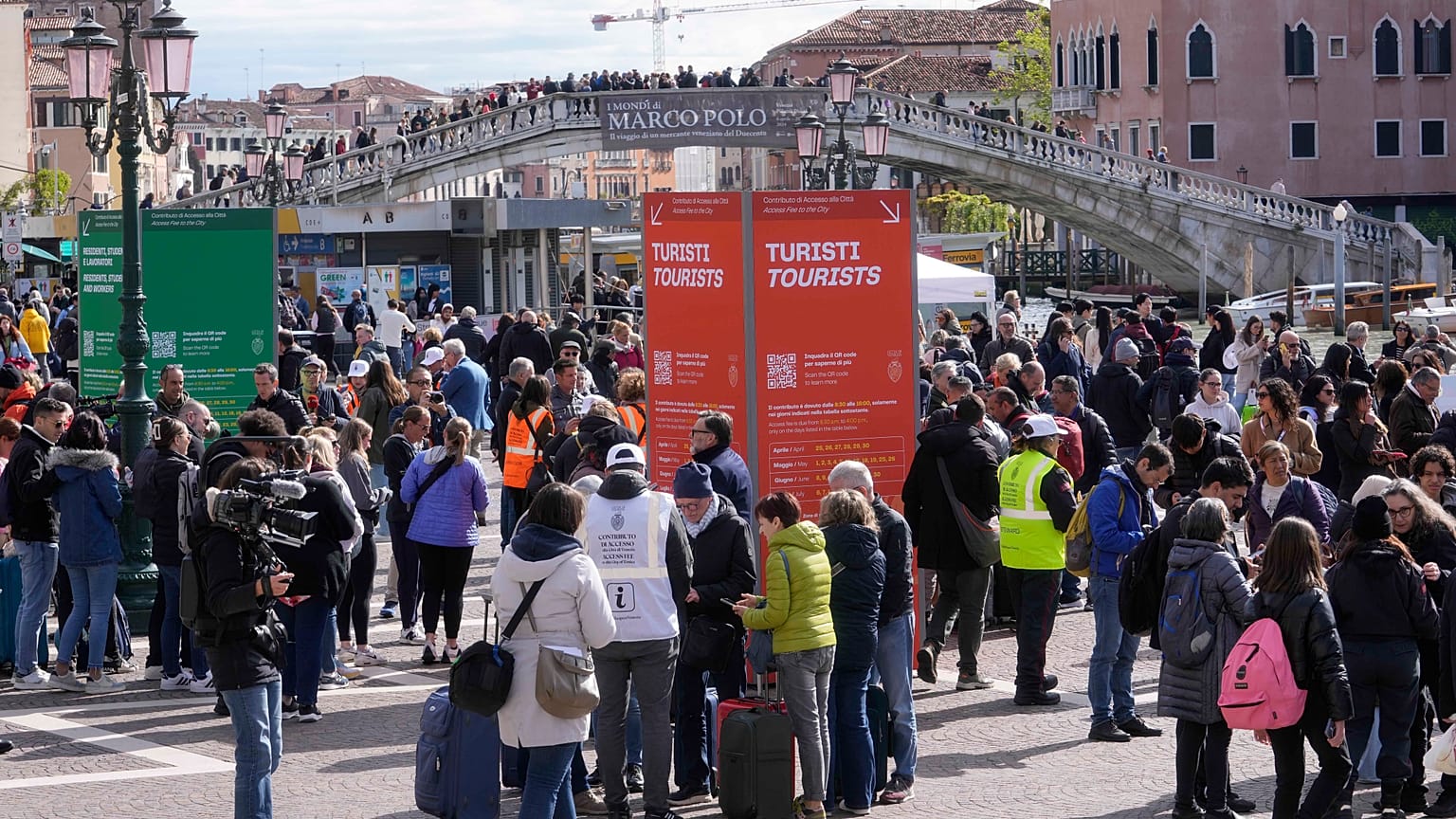 Operátorok ellenőrzik a turisták belépőjegyeit Velencében, az állomás előtt 2024 áprilisában