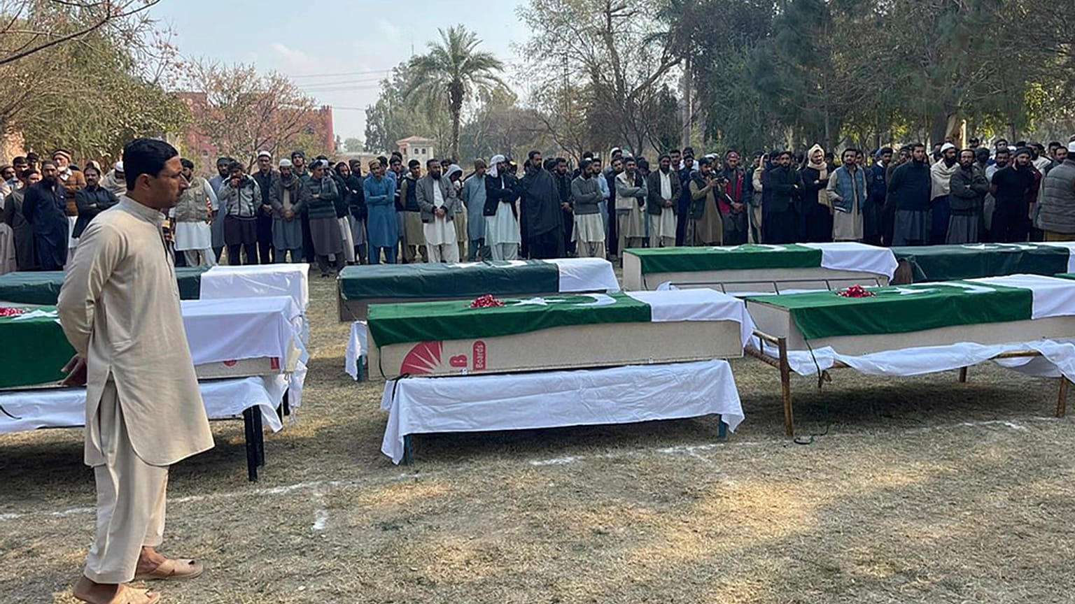 صورة أرشيفية لأشخاص يحضرون صلاة الجنازة على ضباط الشرطة الذين قُتلوا في هجوم شنته طالبان على مركز للشرطة في ديرا إسماعيل خان، باكستان