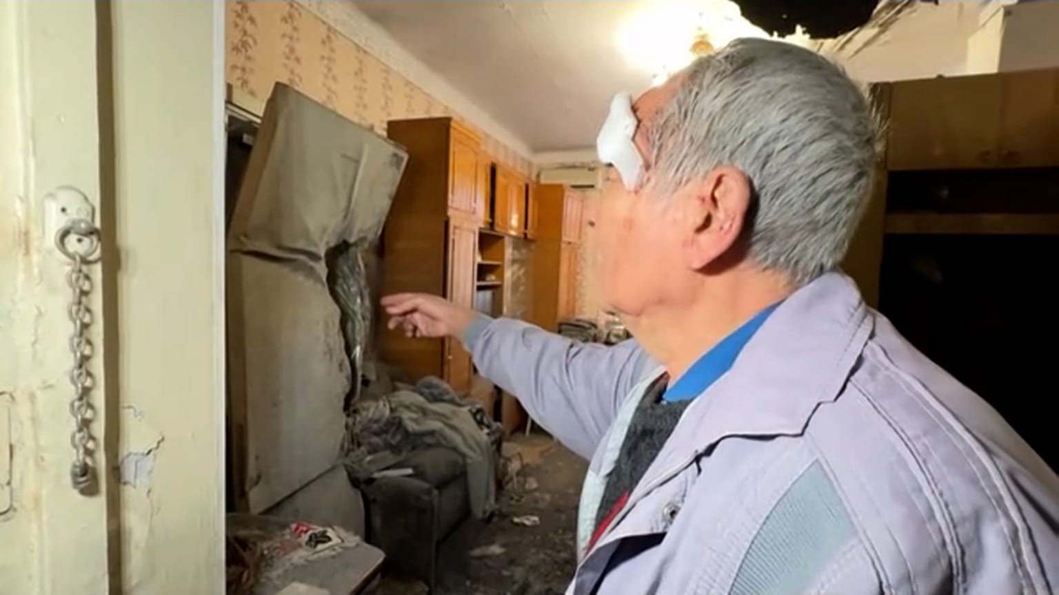 Pavlo Temeriantseva, um residente de Kherson, mostra a trajetória do foguetão através da sua cozinha.