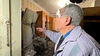 Pavlo Temeriantseva, um residente de Kherson, mostra a trajetória do foguetão através da sua cozinha.