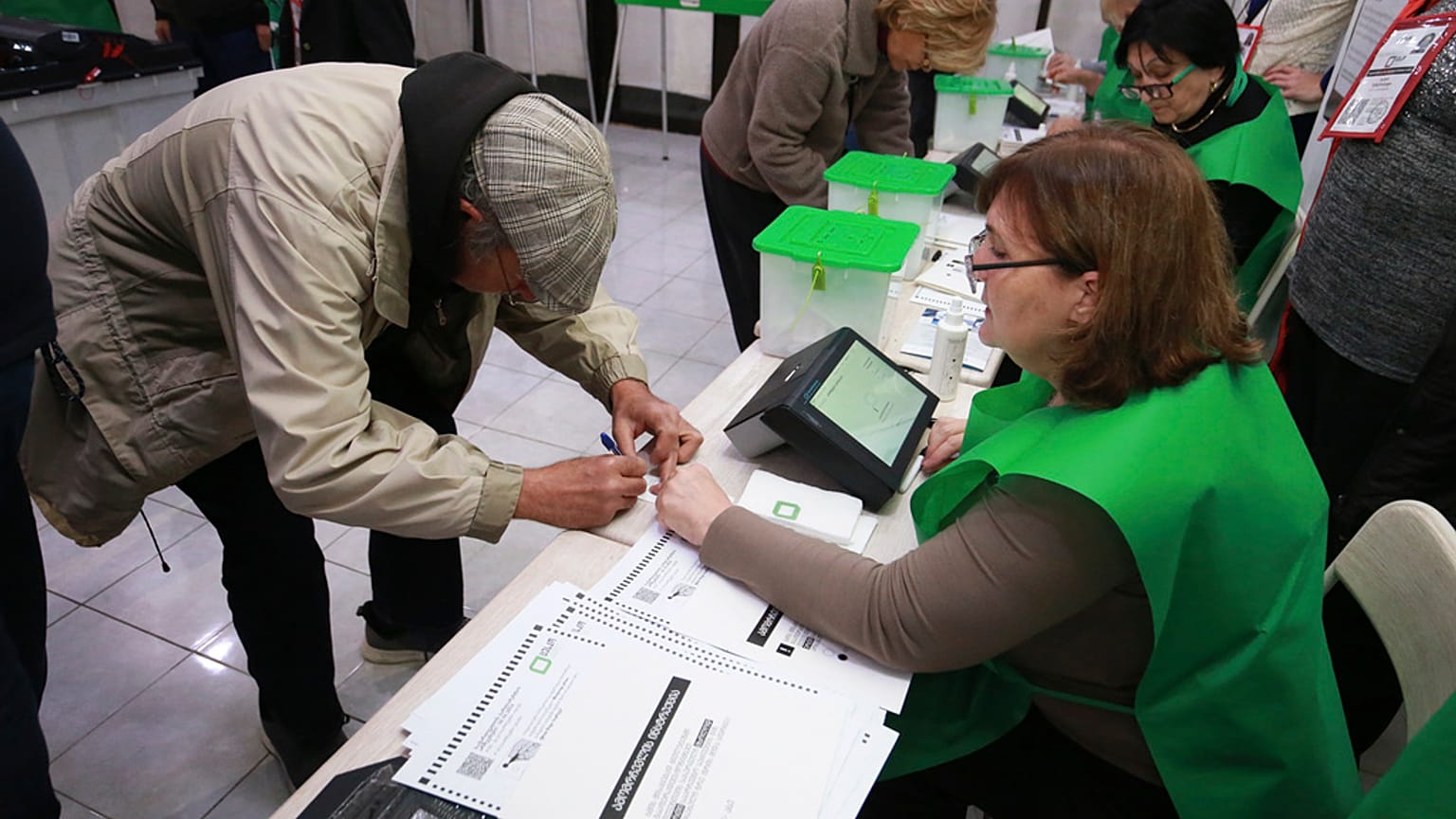 People get their ballots at a polling station during the parliamentary election in Tbilisi, Georgia, Saturday, Oct. 26, 2024.