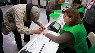 People get their ballots at a polling station during the parliamentary election in Tbilisi, Georgia, Saturday, Oct. 26, 2024.