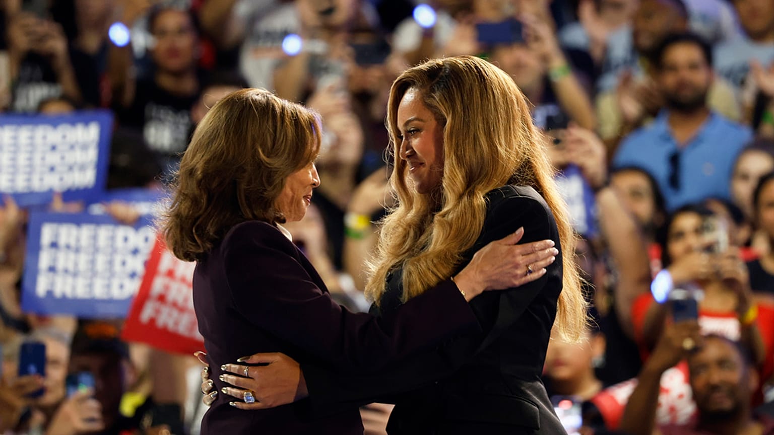 A artista musical Beyoncé, à direita, e a candidata democrata à presidência, a vice-presidente Kamala Harris, à esquerda, abraçam-se no palco durante um comício de campanha na sexta-feira, 25 de outubro de 2024,