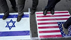 DATEI - Iranische Demonstranten stehen auf US-amerikanischen und israelischen Flaggen bei einer anti-israelischen Versammlung auf dem Felestin (Palästina) Platz in Teheran, Iran, Dienstag, 8. Oktober 2024