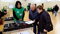 Varias personas depositan su voto en un colegio electoral durante las elecciones parlamentarias en Tiflis, Georgia, el sábado 26 de octubre de 2024. 