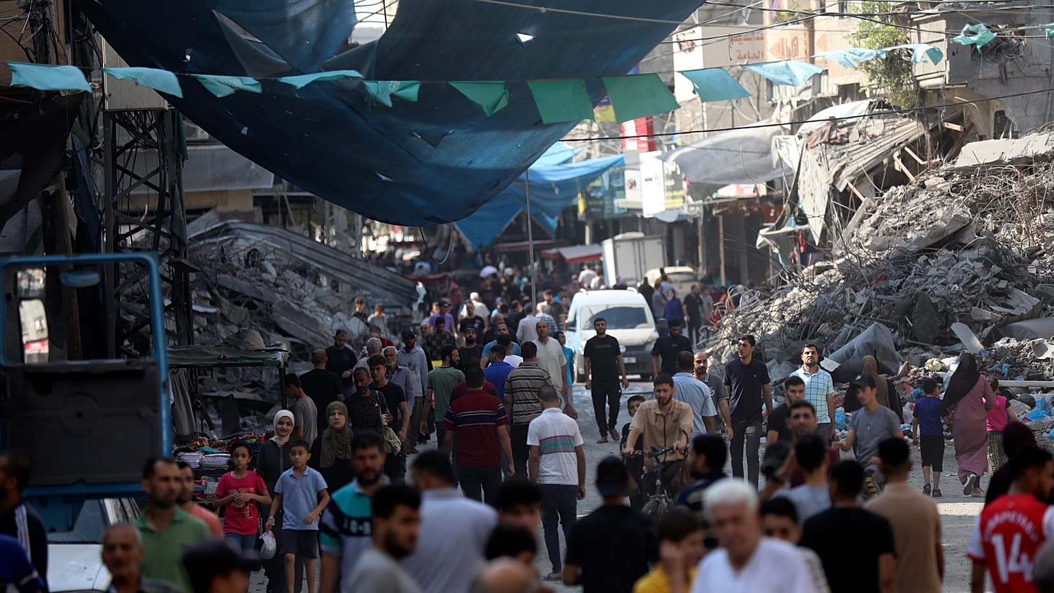 فلسطينيون يمشون في سوق الشارع في مخيم جباليا للاجئين، شمال قطاع غزة، الأربعاء 1 نوفمبر/تشرين الثاني 2023، بعد غارة جوية إسرائيلية