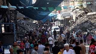 فلسطينيون يمشون في سوق الشارع في مخيم جباليا للاجئين، شمال قطاع غزة، الأربعاء 1 نوفمبر/تشرين الثاني 2023، بعد غارة جوية إسرائيلية