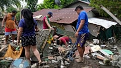 Filipinler'de 26 Ekim 2024 Cumartesi günü Tropik Fırtına Trami'nin tetiklediği toprak kaymasının ardından bölge sakinleri hasar gören evlerinden kişisel eşyalarını kurtarmaya çalışıyor.