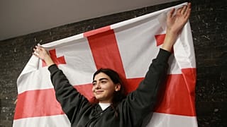 Ein Anhänger der Koalition für den Wandel hält eine georgische Flagge am Sitz der Koalition nach Schließung der Wahllokale bei den Parlamentswahlen in Tiflis, Georgien, 2024.