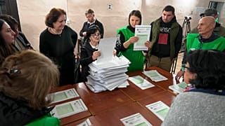 Seçim komisyonu üyeleri, Gürcistan'ın başkenti Tiflis'te yapılan parlamento seçimlerinin ardından bir oy verme merkezinde oyları sayıyor, 26 Ekim 2024.