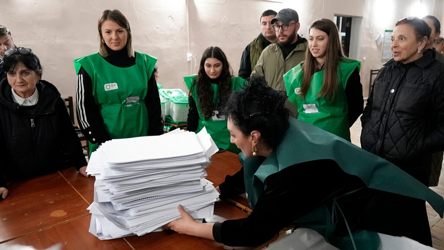 Miembros de una comisión electoral se preparan para contar papeletas en un colegio electoral tras las elecciones parlamentarias en Tiflis, Georgia, el sábado 26 de octubre de 2024. 
