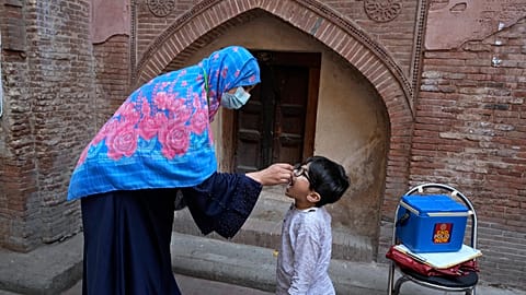 A health worker administers a polio vaccine to a child in Pakistan in October 2024.