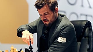 Norway's World Chess Champion Magnus Carlsen, makes a move against Ian Nepomniachtchi of Russia, during their Game One of the FIDE World Championship at the Dubai Expo, 2021