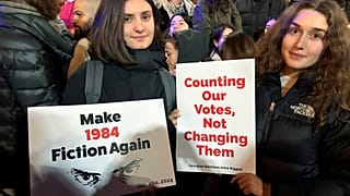 Demonstranten blicken auf einen Fotografen, während sie Plakate während eines Protestes der Opposition gegen die Ergebnisse der Parlamentswahlen in Tiflis, Georgien, am Montag, 28. Oktober, halten,