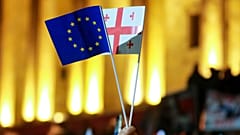 Демонстрант размахивает флагами ЕС и Грузии во время акции протеста оппозиции против результатов парламентских выборов в Тбилиси, Грузия, 28 октября 2024 года.