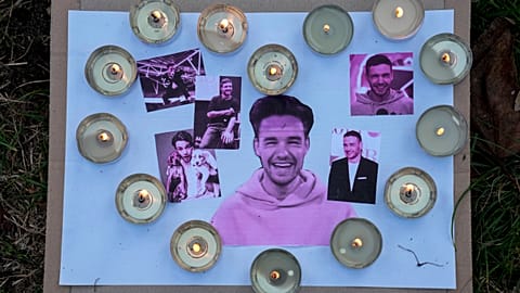 Three people charged in connection with the death of Liam Payne - Pictured here: Pictures and candles are placed as fans gather to pay tribute to Payne 