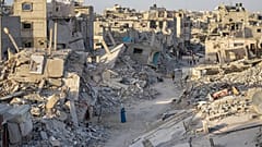 DATEI: Palästinenser gehen durch die Zerstörung, die die israelische Luft- und Bodenoffensive auf Khan Younis, Gazastreifen, hinterlassen hat, 12. September 2024