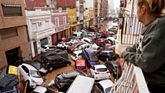 Une femme regarde de son balcon les véhicules coincés dans la rue lors des inondations à Valence.