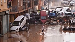 Des habitants regardent des voitures empilées après avoir été emportées par les inondations à Valence, en Espagne, mercredi 30 octobre 2024.