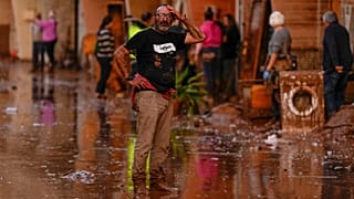 A man reacts in front of houses affected by floods in Utiel, Spain, Wednesday, Oct. 30, 2024.