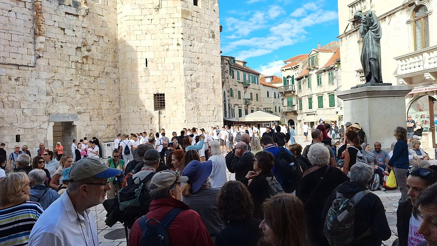 Touristen warten auf Tagesausflüge und Kreuzfahrten auf dem Platz des Volkes in Split
