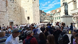 Turistas à espera de excursões e cruzeiros na Praça do Povo, em Split, Croácia.