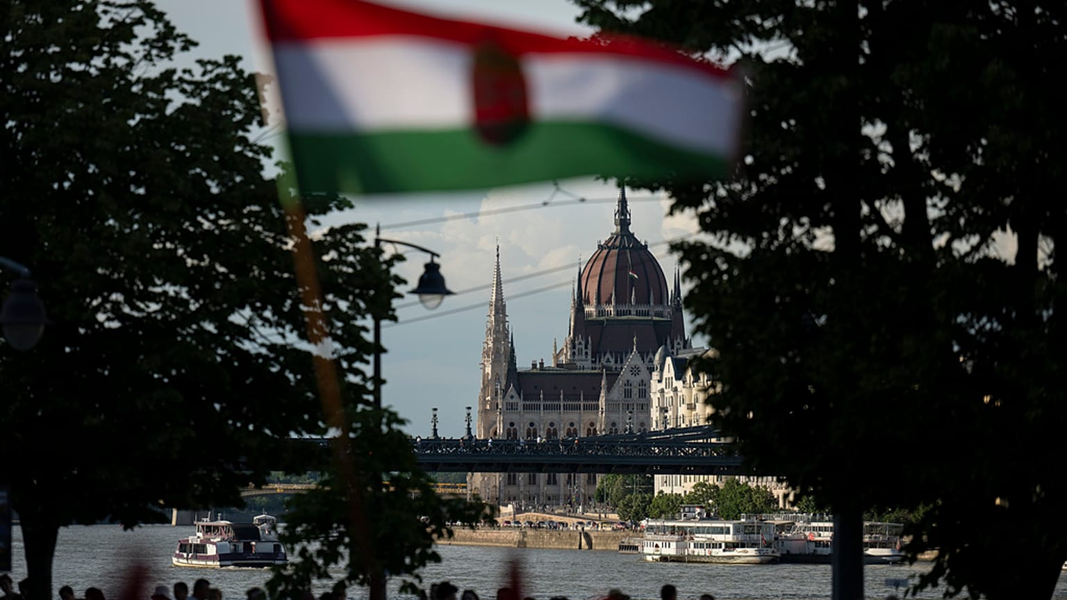 nsanlar Budapeşte'de Tuna nehrinin yanında Macar ulusal bayrağını dalgalandırıyor, 30 Mayıs 2024