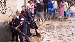 أشخاص يسيرون في الشوارع التي غمرتها المياه في فالنسيا، إسبانيا، الأربعاء 30 أكتوبر 2024.