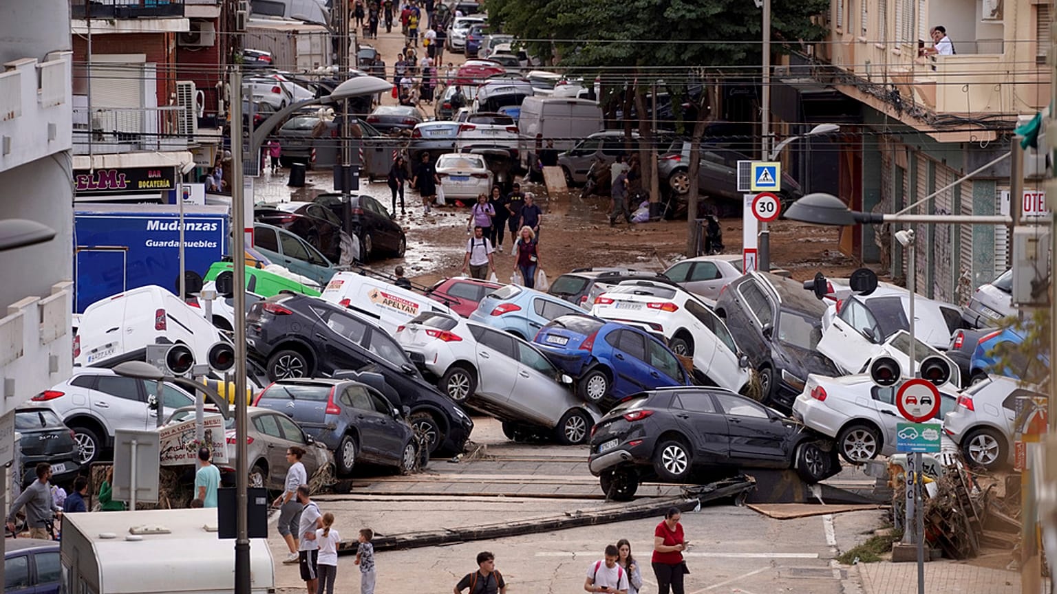 Varias personas caminan por una calle inundada en Valencia, España.