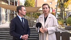 Der schwedische Regierungschef Ulf Kristersson und seine dänische Amtskollegin Mette Frederiksen sprechen vor einer Kindertagesstätte in Dänemark