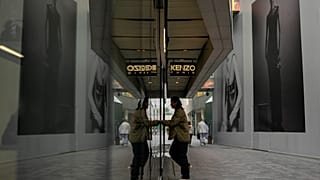 A man walks into a fashion boutique as shoppers tour at an outdoor shopping mall in Beijing, Thursday, Oct. 31, 2024