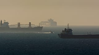 زورق بحري عسكري إسرائيلي، في الوسط، يقوم بدورية بين سفن الشحن في البحر الأبيض المتوسط، بالقرب من ميناء أسدود، إسرائيل، الثلاثاء 15 مارس/آذار 2011