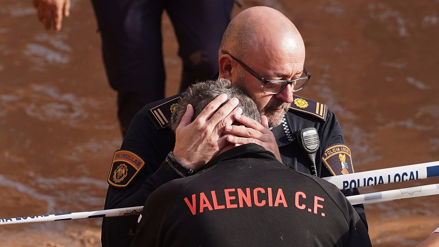 Polícia conforta cidadão em Valência na sequência da tempestade que provocou mais de 150 mortos em Espanha