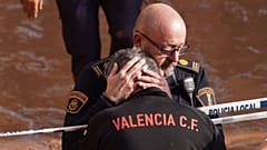 Polícia conforta cidadão em Valência na sequência da tempestade que provocou mais de 150 mortos em Espanha