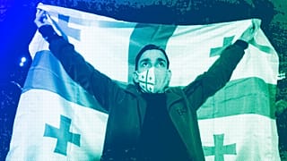A man holds a Georgian flag during an opposition protest against the results of the parliamentary election in Tbilisi, 28 October 2024